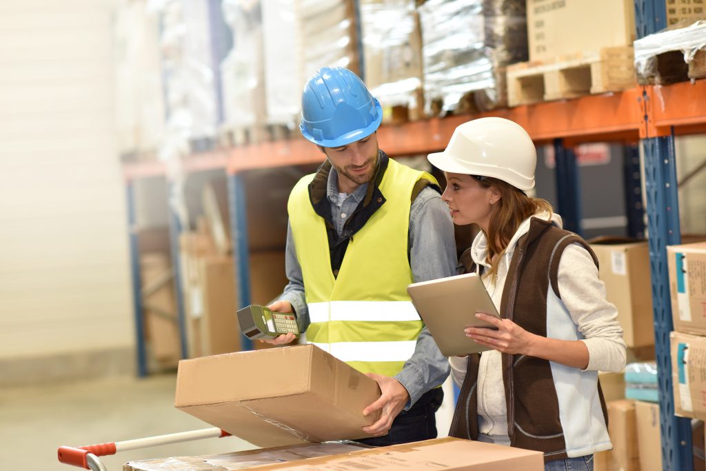 two managers of warehouse services with packages and clipboards