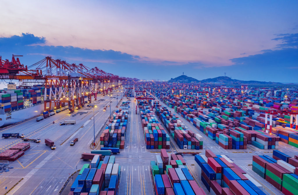 Container ship in export and import business and logistics. Shipping cargo to harbor by crane. Water transport International. Aerial view